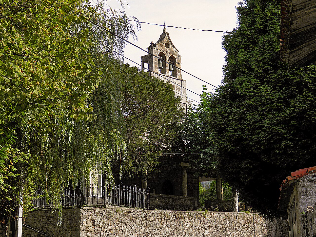 Espadaña de piedra con dos campanas de la iglesia de Santiago de Caravia