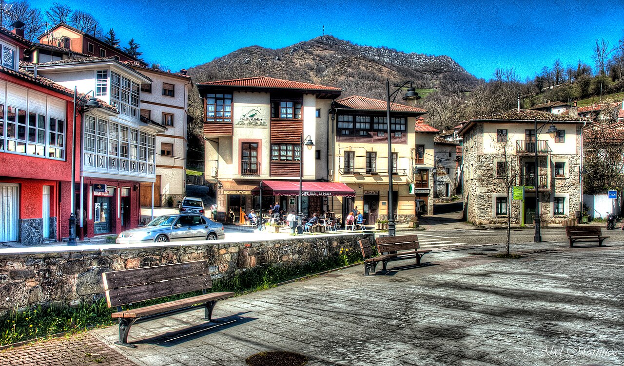 Plaza de Campo de Caso, capital del concejo, con casas de colores y la montaña al fondo